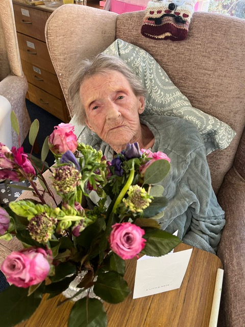 Female resident with a vase of pink roses