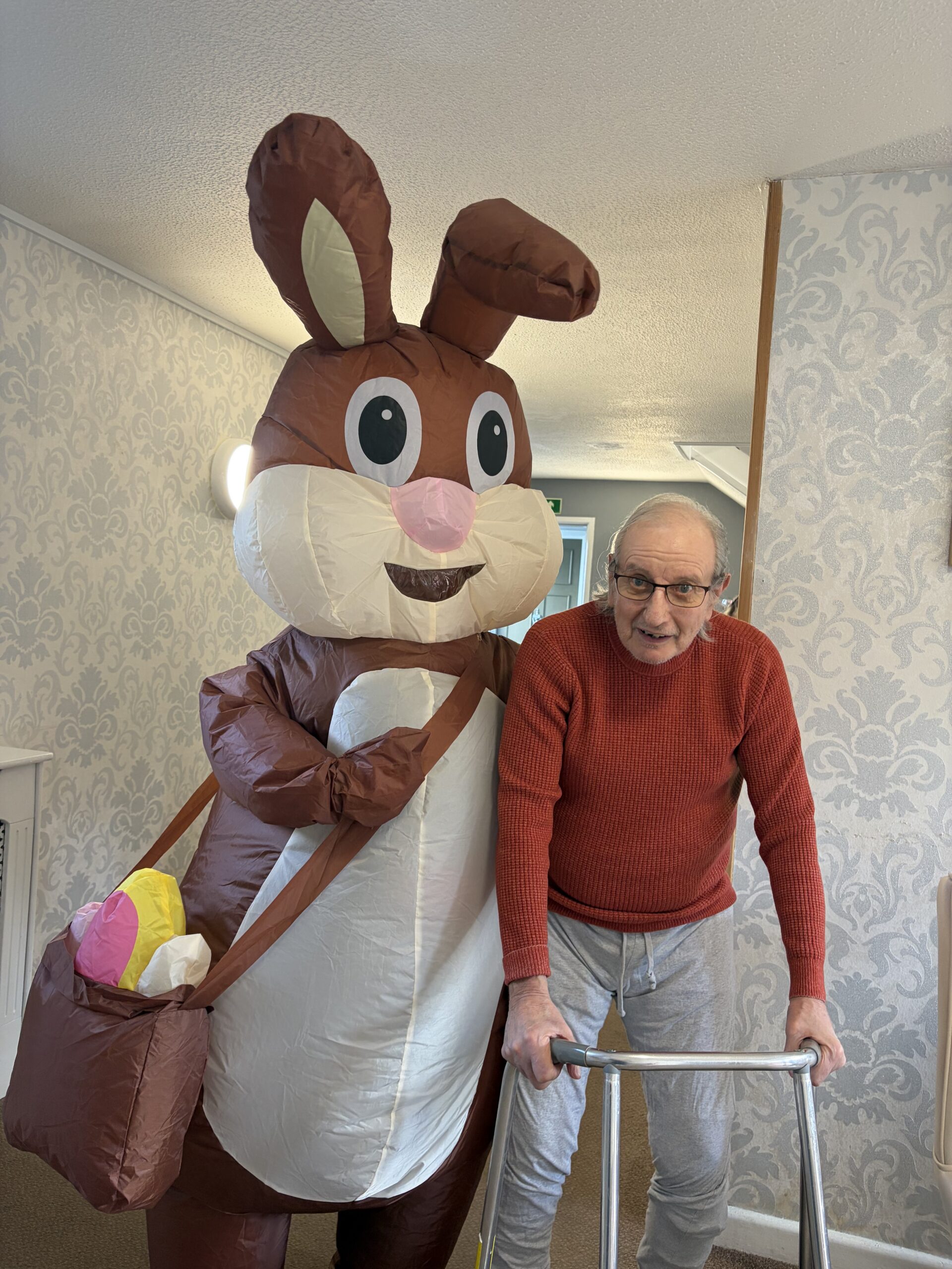 Easter bunny stood with a male resident posing for a photo scaled