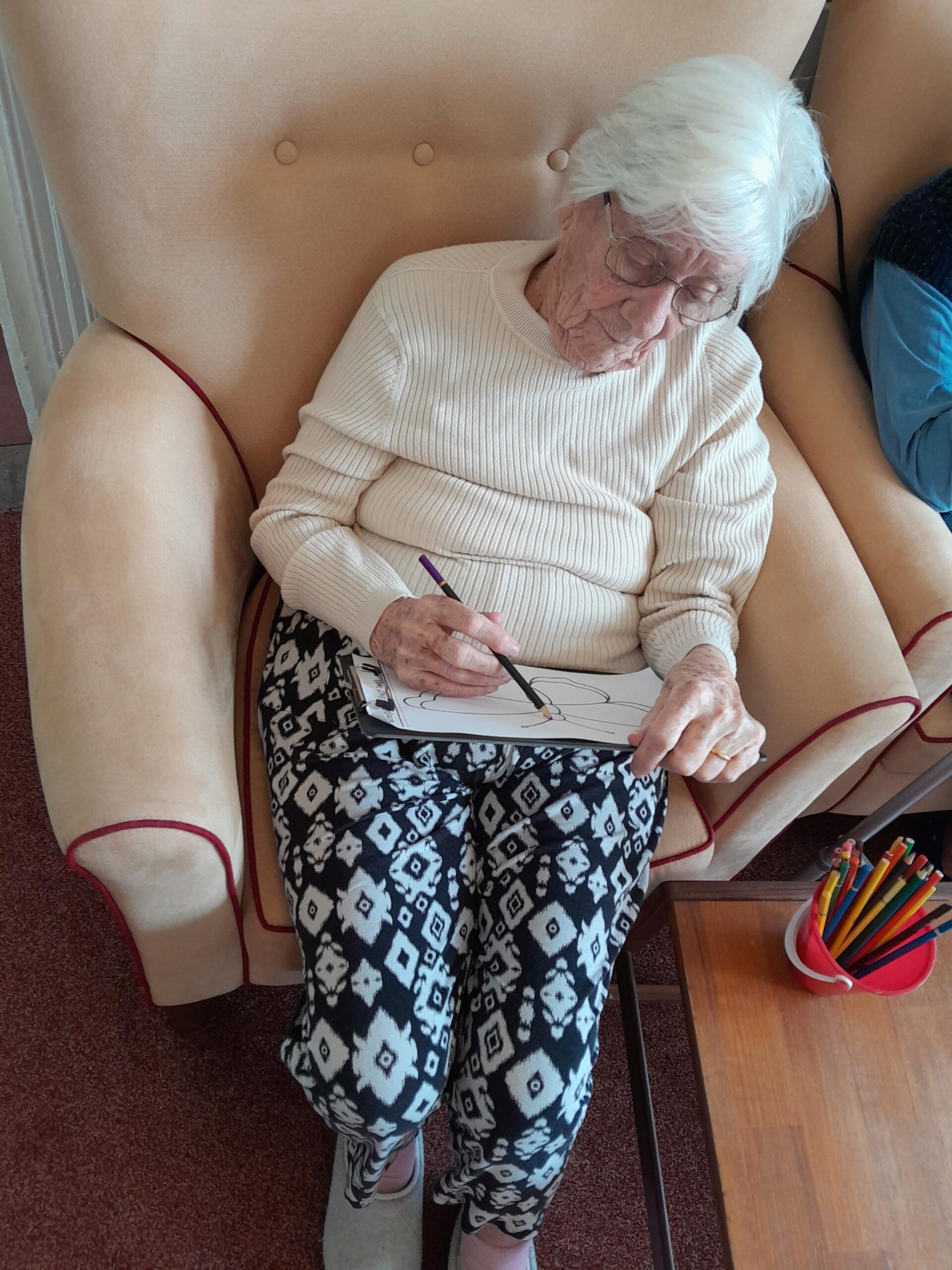 Female resident colouring in a butterfly with colour pencils scaled