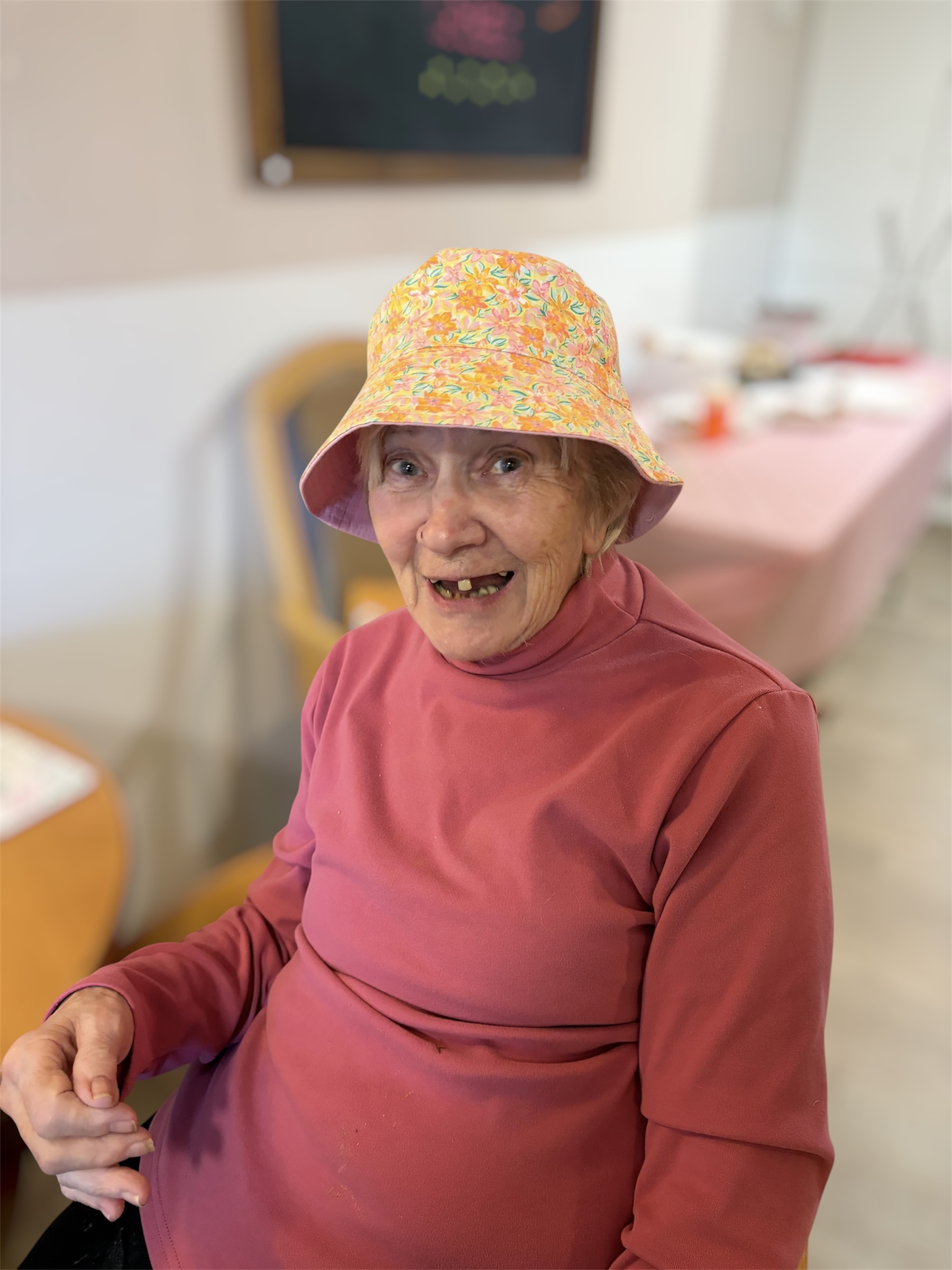 Female resident wearing a yellow flower print bucket hat