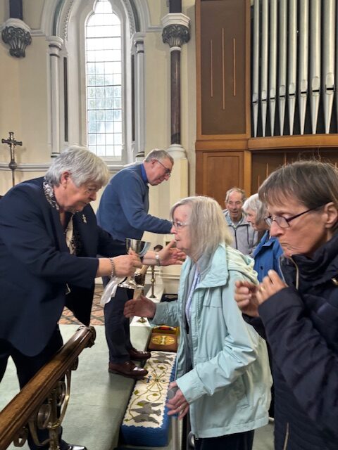 Pastor Kim giving Holy Communion to the church rotated