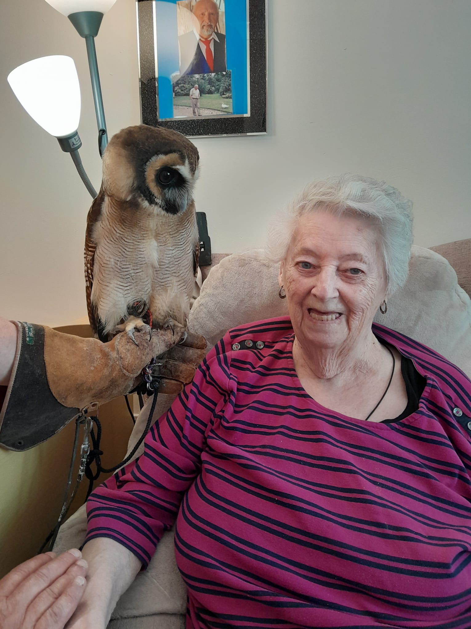 Angie smiling seated next to Bill the Owl