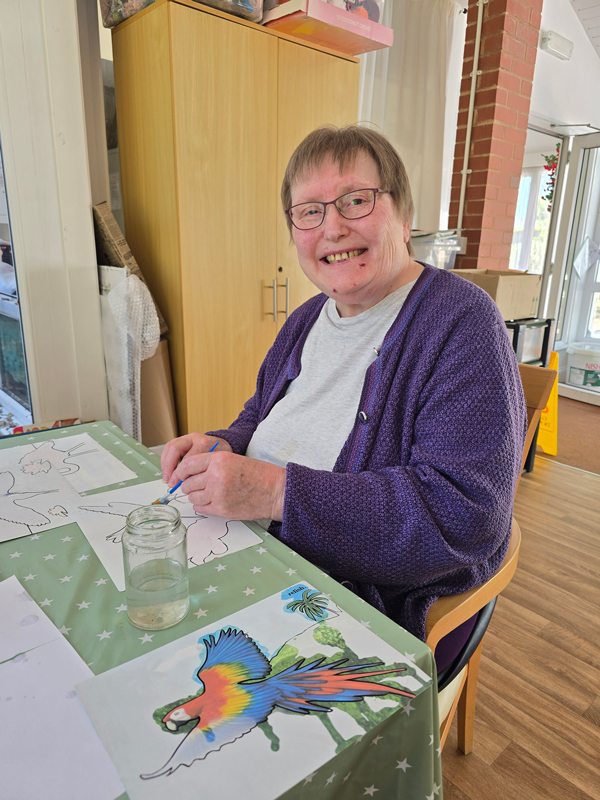 Chris using watercolours to paint a parrot