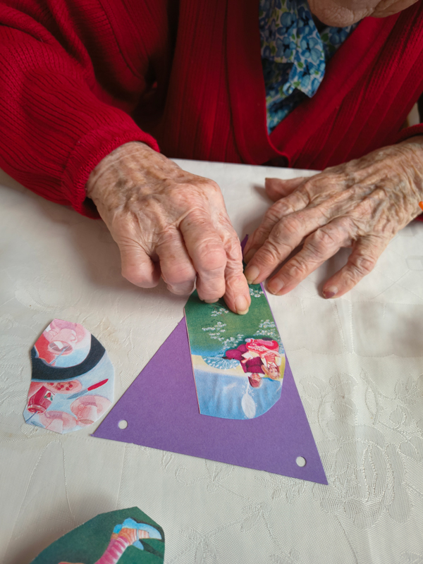Close up of a resident sticking a picture of Alice to her bunting