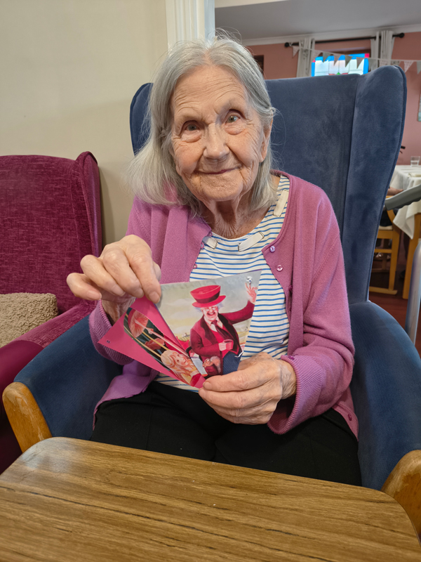 Female resident proudly showing her 2 finished pieces of bunting