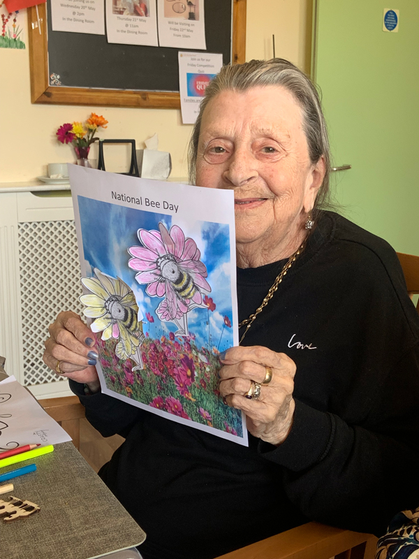 Female resident smiling holding up her finished picture