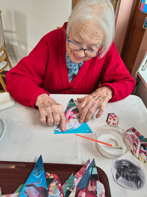 Female resident sticking a picture of a white rabbit onto paper bunting