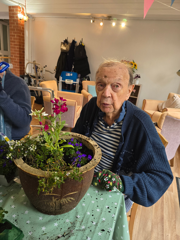 Horace busy planting a large pot with flowers