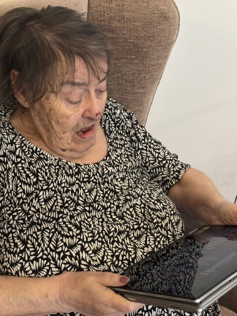 Jeanette holding a tablet with a wonderful surprised look on her face rotated