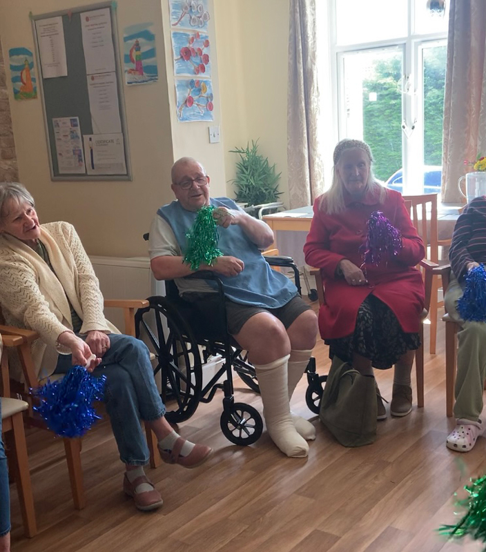 Other residents waving pompoms enjoying the performance