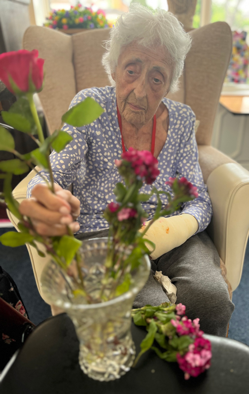 Pauline placing a pink rose in her vase