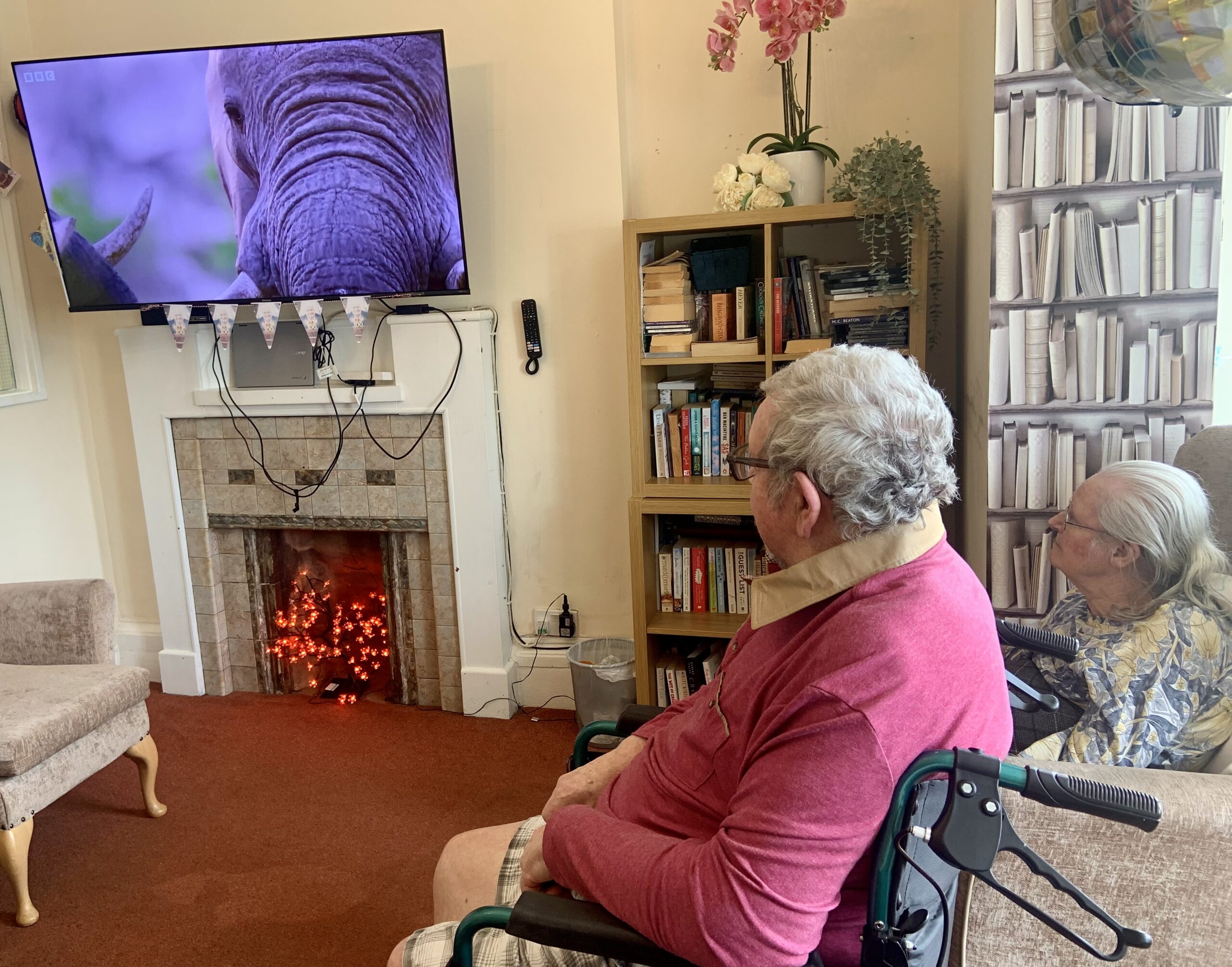 Residents seated around a screen showing an episode of Our Planet scaled