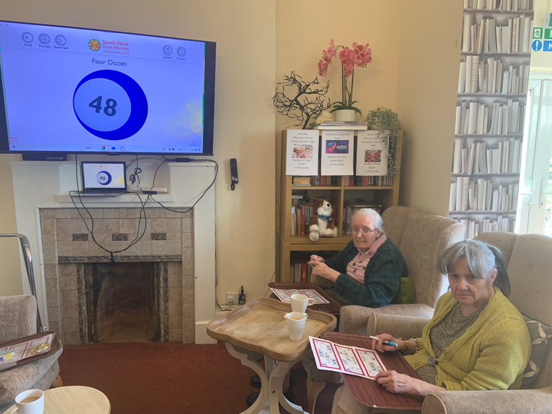Residents seated around the screen showing the bingo ball numbers