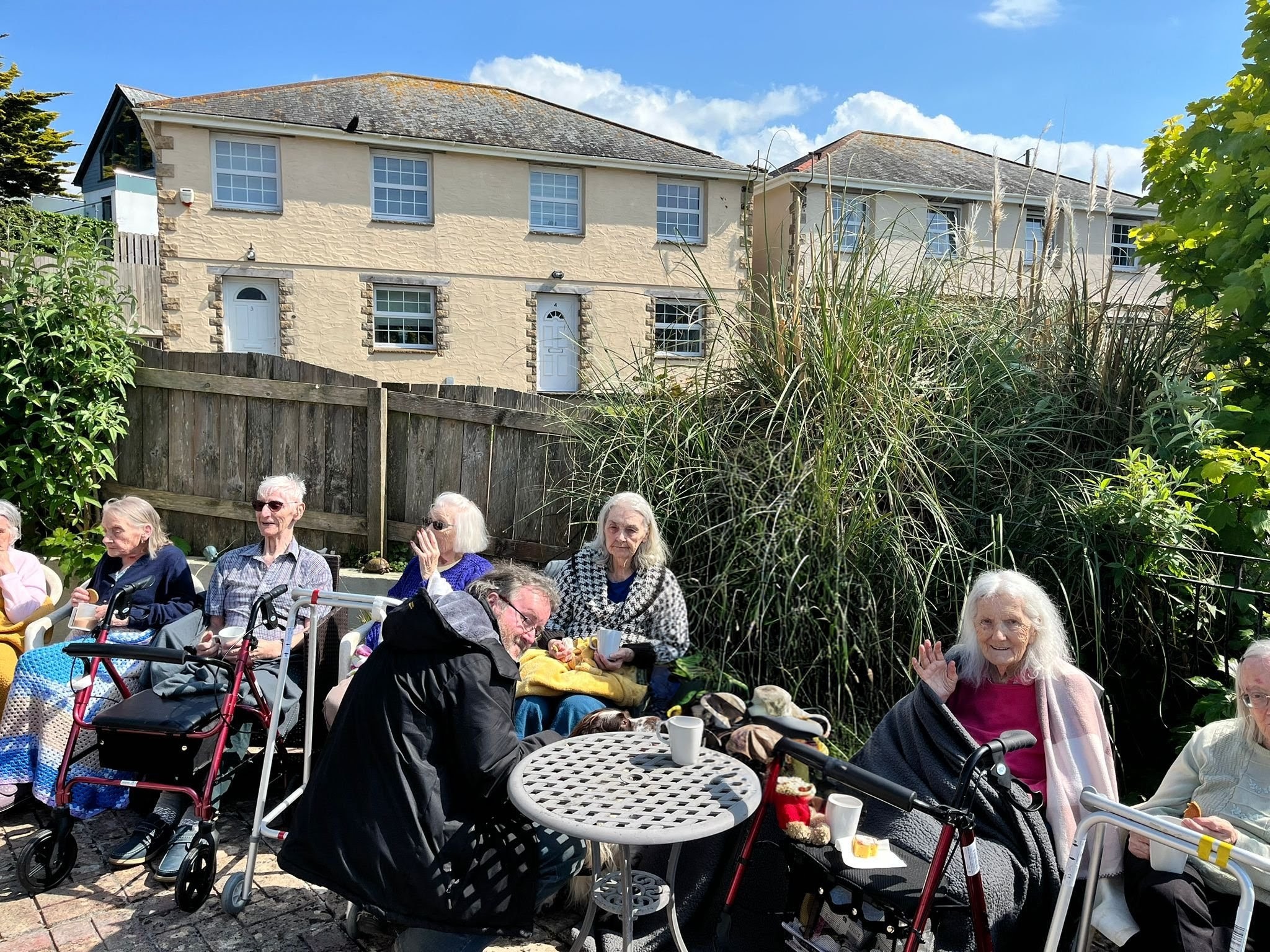 Residents seated together outside in the sunshine