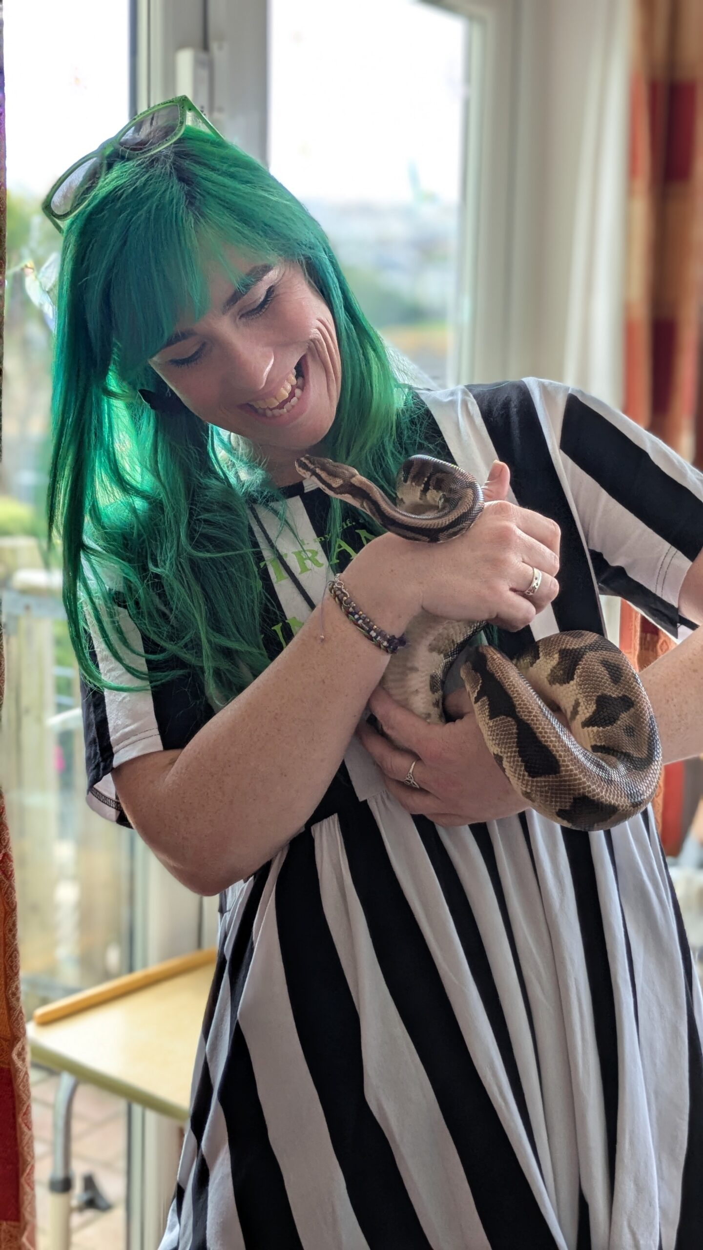 Staff member Jess holding and looking st the face of a python scaled