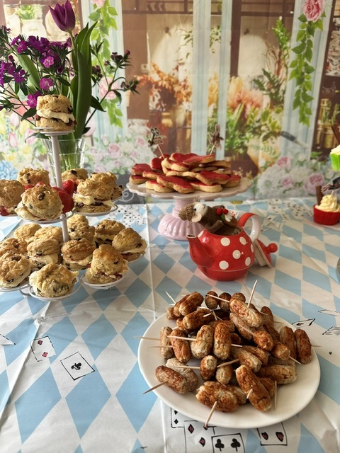 Table laid out with cakes cupcakes and Mad Hatter decorations 3