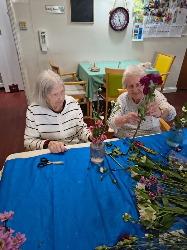 Two female residents chatting together about their flowers
